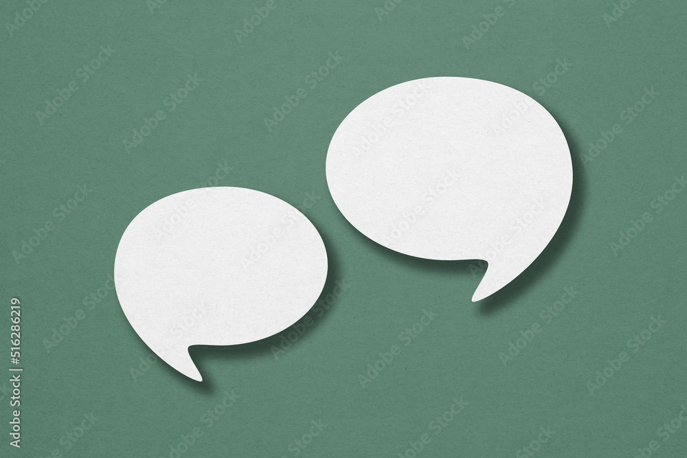 two blank white speech bubble paper cut ,including clipping path on green paper background. Conceptual image about communication and social media two blank white speech bubble paper cut ,including clipping path on green paper background. Conceptual image about communication and social media