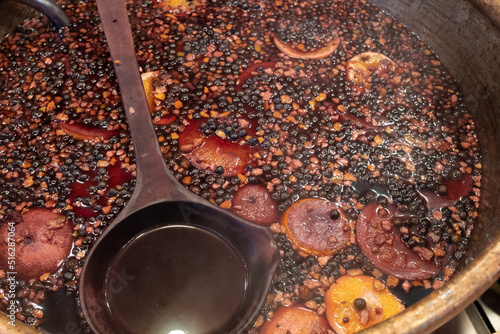 Wallpaper Mural Bowl of traditional English hot spicy mulled wine with cloves, cinnamon sticks, dried fruit and red wine on sale at Bath Christmas market