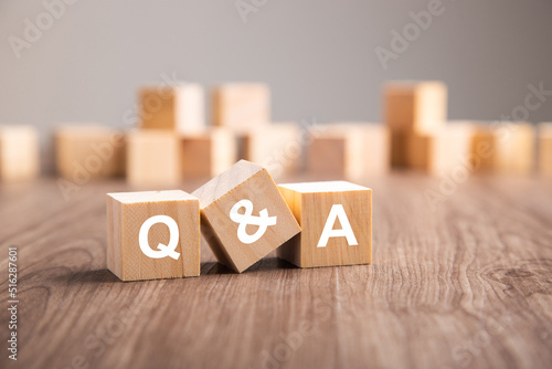 Three wooden cubes with the letters Q and A. photo