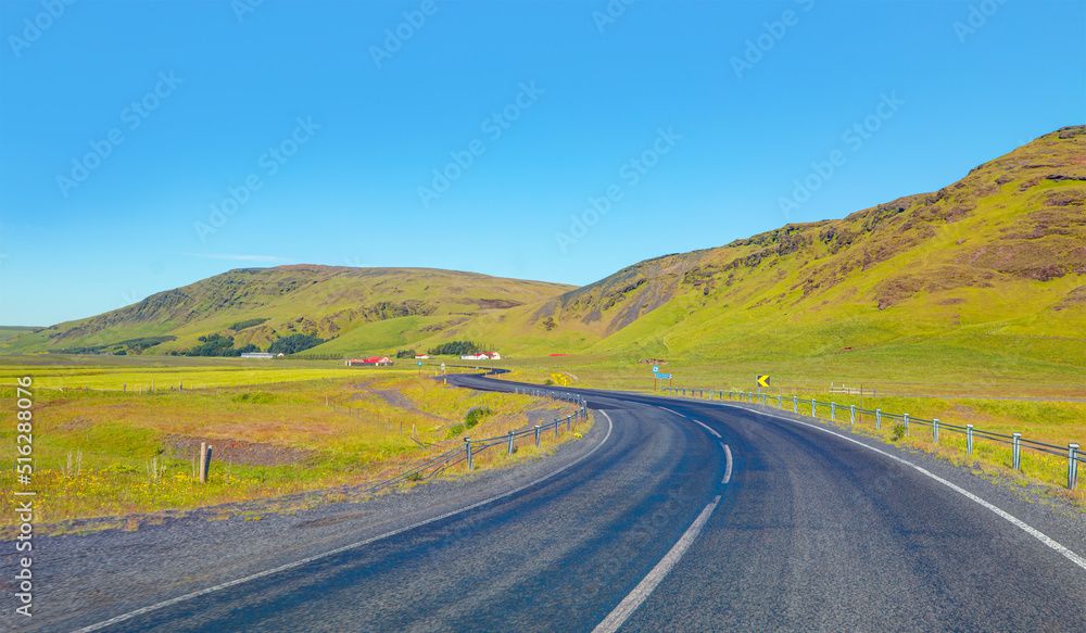 S-curved asphalt road leads to the mountains in volcanic area - İceland S-curved asphalt road leads to the mountains in volcanic area - İceland