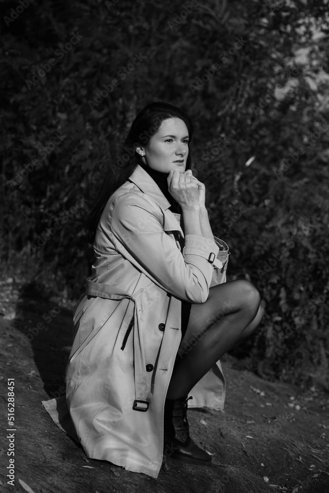 Black and white outdoors portrait of a young woman in a grey coat Black and white outdoors portrait of a young woman in a grey coat