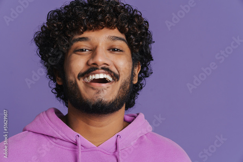 Portrait of young indian handsome curly happy smiling man