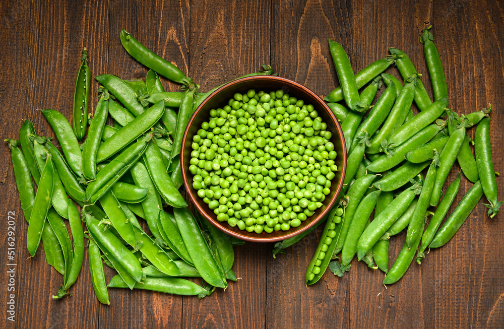 green sweet peas on a dark wooden background, still life, concept of fresh and healthy food green sweet peas on a dark wooden background, still life, concept of fresh and healthy food