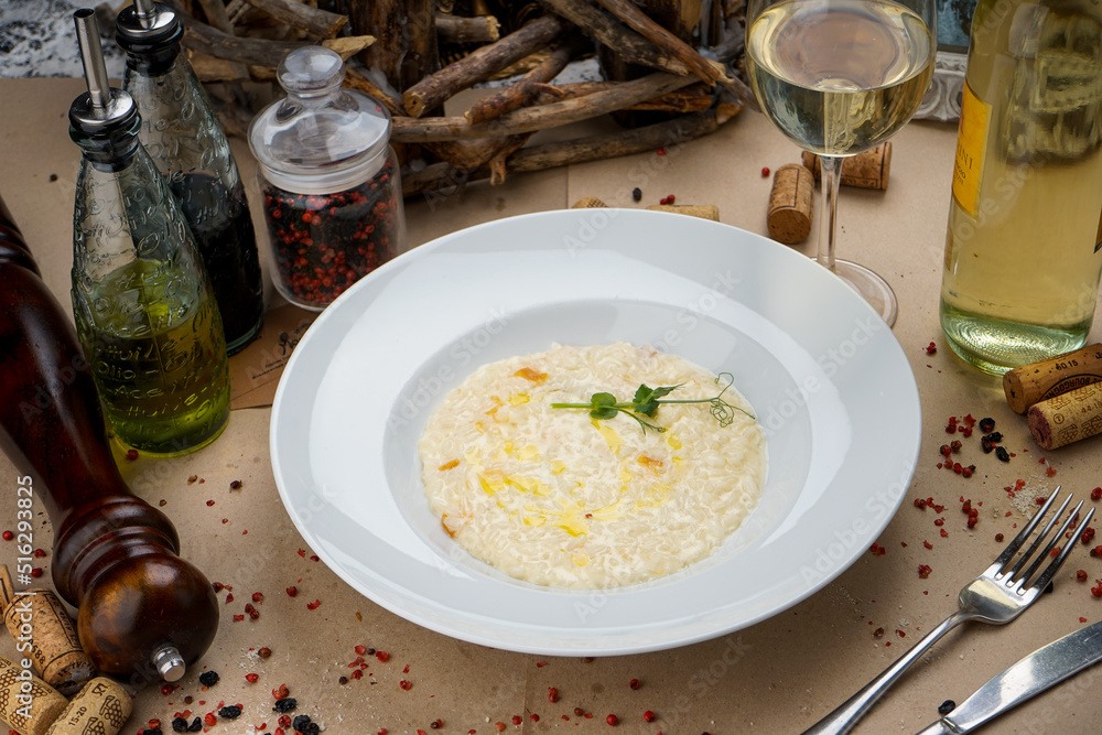rice risotto in a white plate on a background with a glass of wine
rice risotto in a white plate on a background with a glass of wine