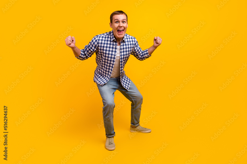 Happy winner. Crazy young handsome man gesturing screaming fist up aim isolated shine color background Happy winner. Crazy young handsome man gesturing screaming fist up aim isolated shine color background