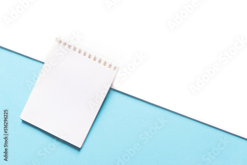 blank note with open notepad on white and blue background close up