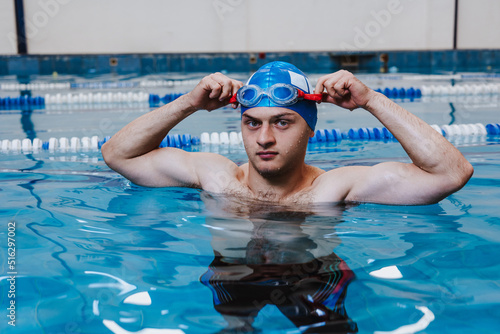hispanic young man swimmer athlete wearing cap and goggles in a swimming training at the Pool in Mexico Latin America 