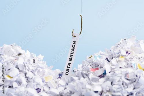 Fototapete Word Data breach hooked on fishing hook pulled from pile of shredded documents o