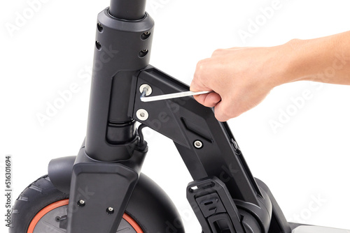 Hand repairing electrical scooter on white background. Repair service for fixing electrical escooters. Technological concept. photo