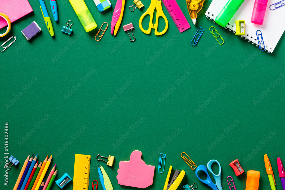 Back to school concept. Creative layout with colorful school supplies on green background. Flat lay, top view, copy space Back to school concept. Creative layout with colorful school supplies on green background. Flat lay, top view, copy space
