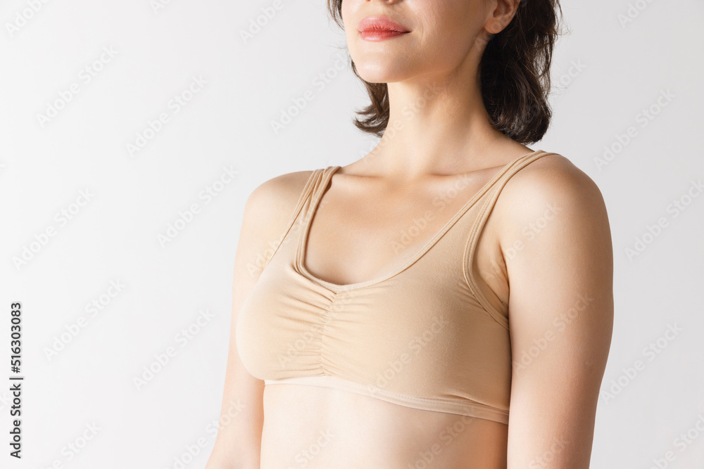 Cropped image of slender female body, breast and shoulders isolated over grey studio background. Concept of beauty, body and skin care, fitness, health Cropped image of slender female body, breast and shoulders isolated over grey studio background. Concept of beauty, body and skin care, fitness, health