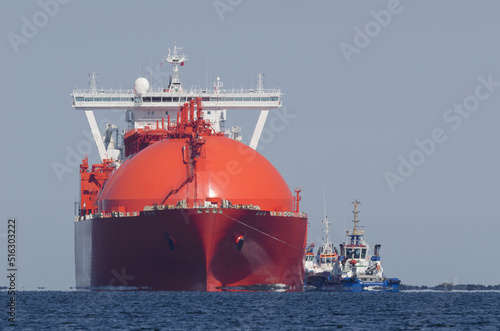 
LNG TANKER - Red ship sails to port with assistance of tugs
