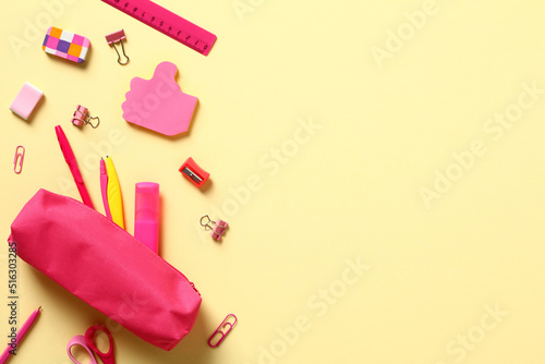 Back to school concept. Flat lay pink school supplies and pencil box on yellow background. photo