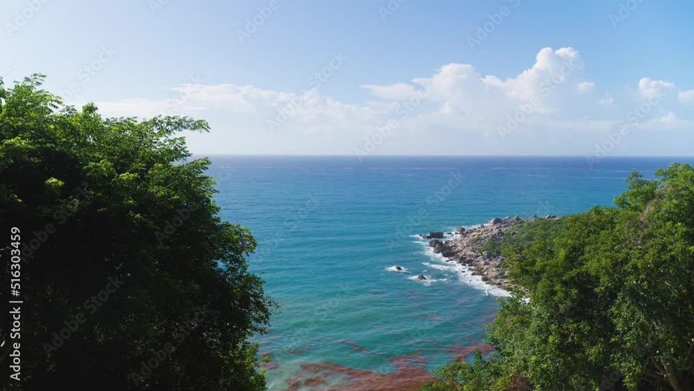 Sea bay off the tropical Caribbean coast. Rocky shore with green vegetation against the backdrop of a bright blue sea. Summer vacation on an exotic Dominican beach. Sea bay off the tropical Caribbean coast. Rocky shore with green vegetation against the backdrop of a bright blue sea. Summer vacation on an exotic Dominican beach.