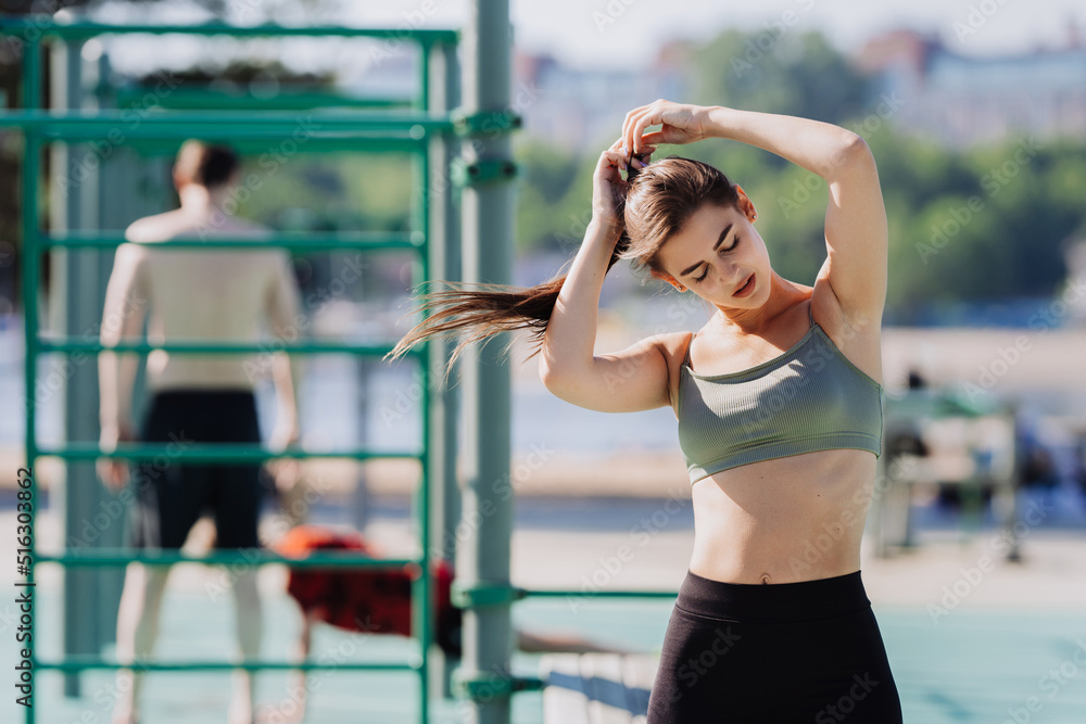 Tired sporty brunette girl at sport court in bra and leggings making ponytail eyes closed. Exhausted spanish girl at her morning training having break. Fitness and healthcare. European girl training. Tired sporty brunette girl at sport court in bra and leggings making ponytail eyes closed. Exhausted spanish girl at her morning training having break. Fitness and healthcare. European girl training.