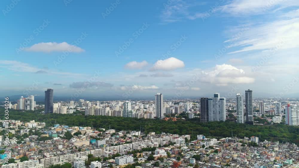 Panorama of Santo Domingo from a bird's eye view. Beautiful skyscrapers against the backdrop of a city park with trees. Cityscape on a sunny summer day. City of Central America, aerial view. Panorama of Santo Domingo from a bird's eye view. Beautiful skyscrapers against the backdrop of a city park with trees. Cityscape on a sunny summer day. City of Central America, aerial view.