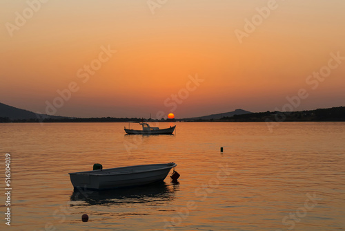 View of small  wooden fishing boats  Aegean sea and landscape at sunset captured in Ayvalik area of Turkey in summer. Beautiful scene.