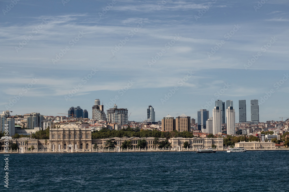 View of historical Dolmabahce Palace by Bosphorus and European side of Istanbul. It is a sunny summer day.