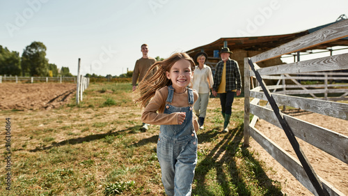 Girl run while her grandparents and brother walk