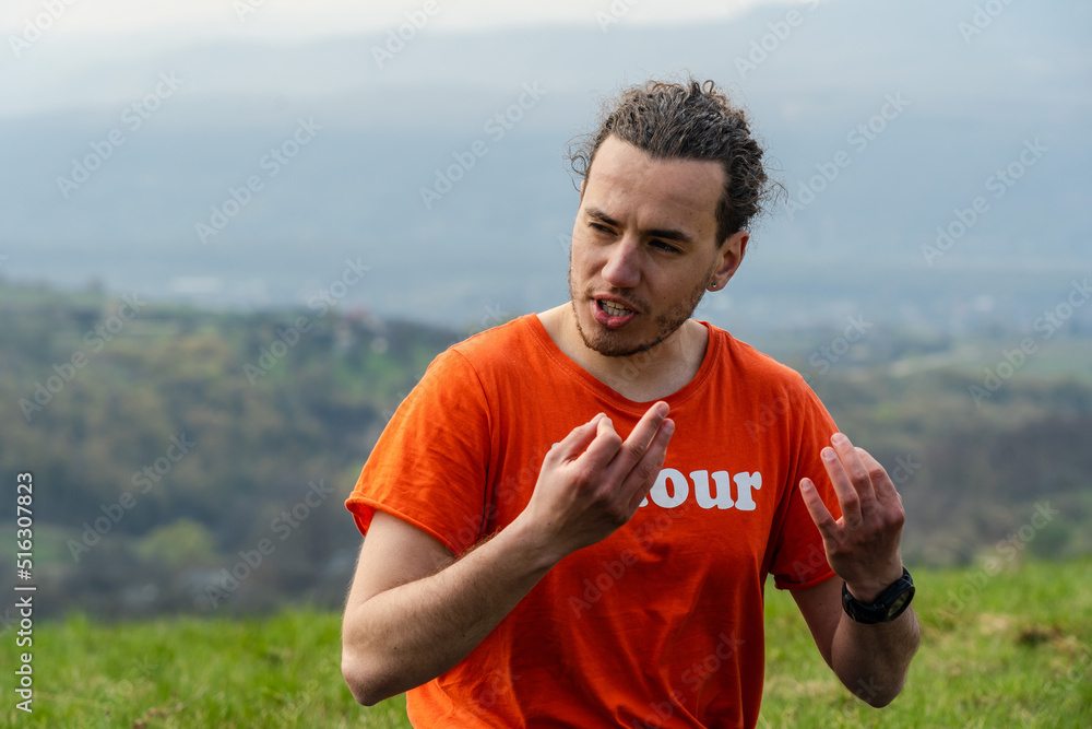 Fototapeta premium Man sitting on the mountain and telling something