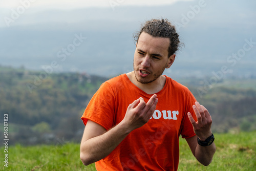 Man sitting on the mountain and telling something