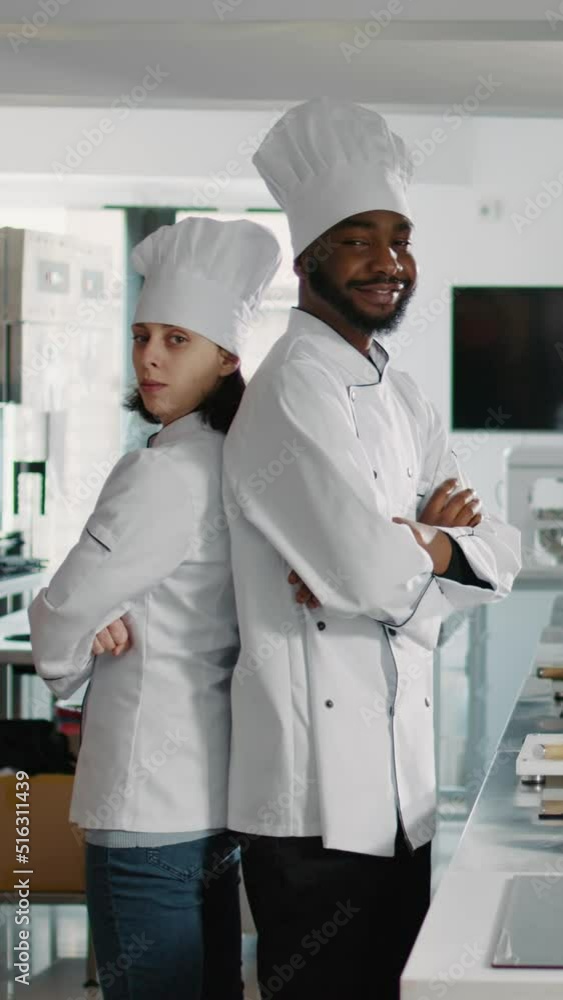 Vertical video: Portrait of chefs doing teamwork to cook food recipe in restaurant kitchen, sitting with arms crossed. Diverse team of cooks preparing to make culinary dish and gourmet meal with fresh Vertical video: Portrait of chefs doing teamwork to cook food recipe in restaurant kitchen, sitting with arms crossed. Diverse team of cooks preparing to make culinary dish and gourmet meal with fresh