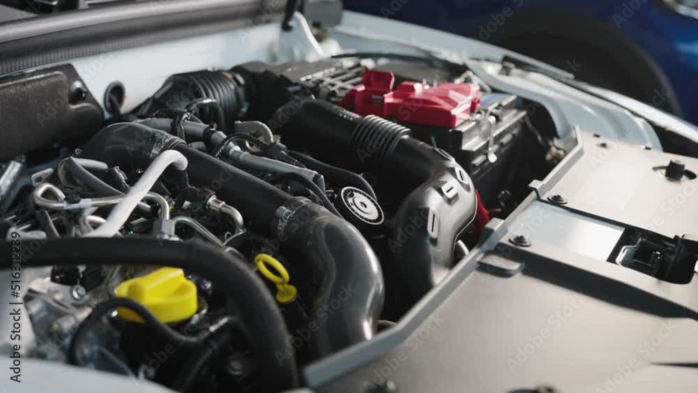 Car engine under the hood of a modern car. New car in the showroom. Car engine under the hood of a modern car. New car in the showroom.