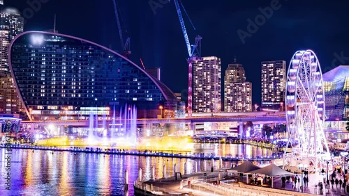 Time lapse of Water Fountain Show while Ferris Wheel spins at Sydney's Darling Harbour during Vivid Festival 2022 photo