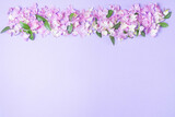 Floral layout of pink and lilac hydrangea flowers on a lilac background. Top view, flat lay. Top border and copy space.
