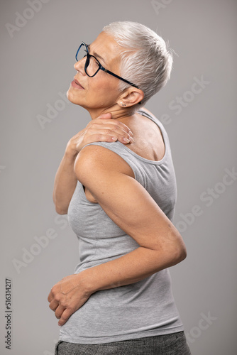 Shoulder and neck and pain, senior old woman with short gray hair and body and spinal muscle problems