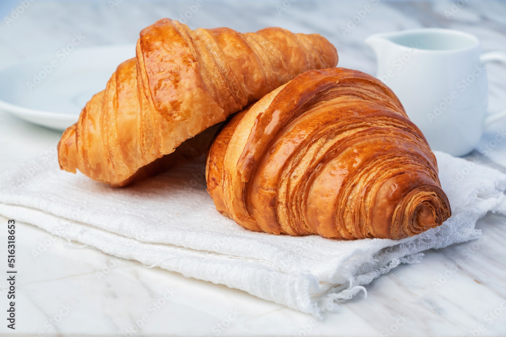 Fresh croissants bread on marble table. French breakfast. Fresh croissants bread on marble table. French breakfast.