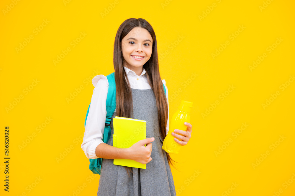 Teenager school girl with backpack holding water bottle isolated on yellow background. Back to school concept. Healthy child. Teenager school girl with backpack holding water bottle isolated on yellow background. Back to school concept. Healthy child.