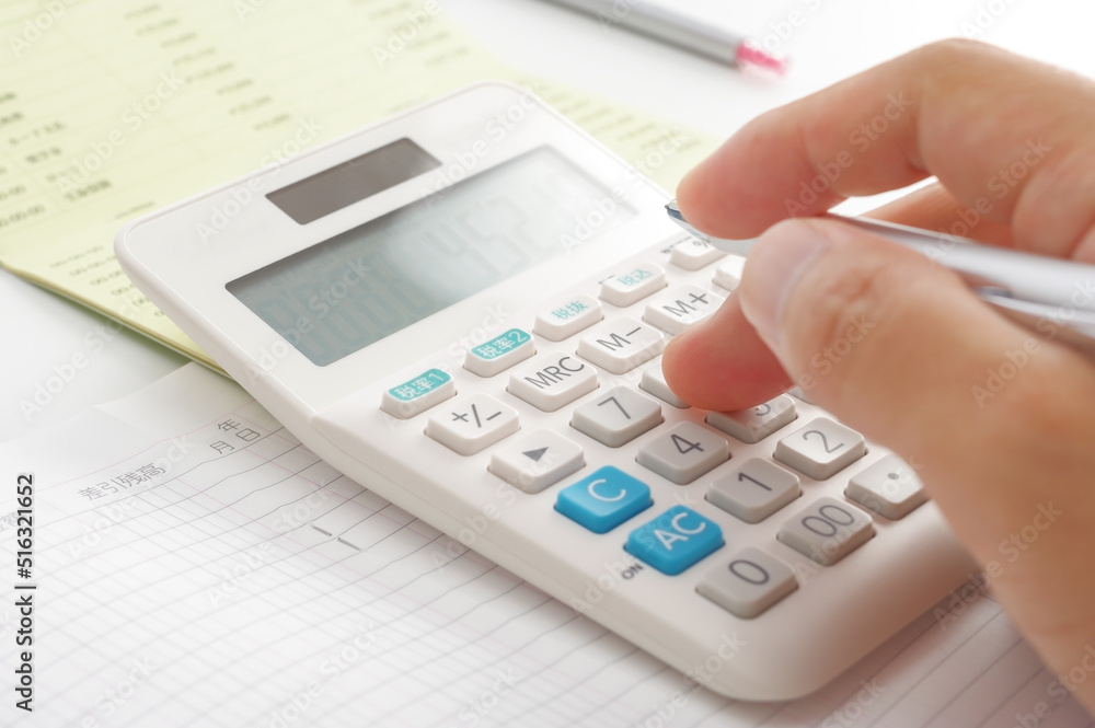 電卓でお金の計算をする人の手元 電卓でお金の計算をする人の手元