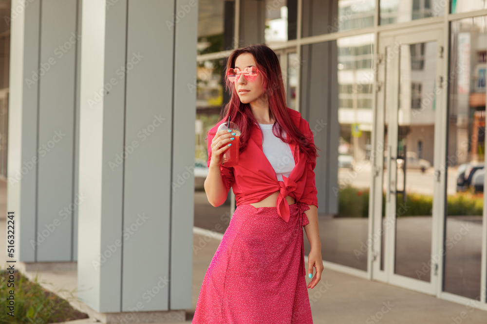 Young beautiful woman with pink hair on a bright background with lemonade Young beautiful woman with pink hair on a bright background with lemonade