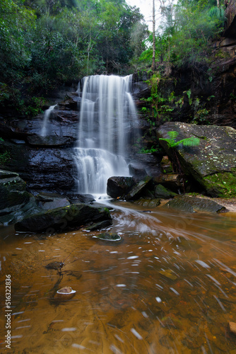 Stream of waterfall flowing into the creek.