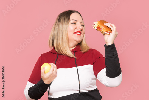 A plump woman chooses between a healthy apple and a harmful . Unhealthy food.