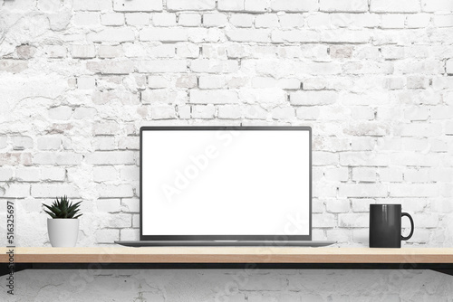 Laptop mockup on desk with brick wall in background. Isolated displaz in white for mockup, app or web page promotion. Plant and coffee mug beside. Front position photo