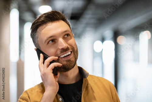 Happy Businessman Speaking By Cellphone Standing In Modern Office