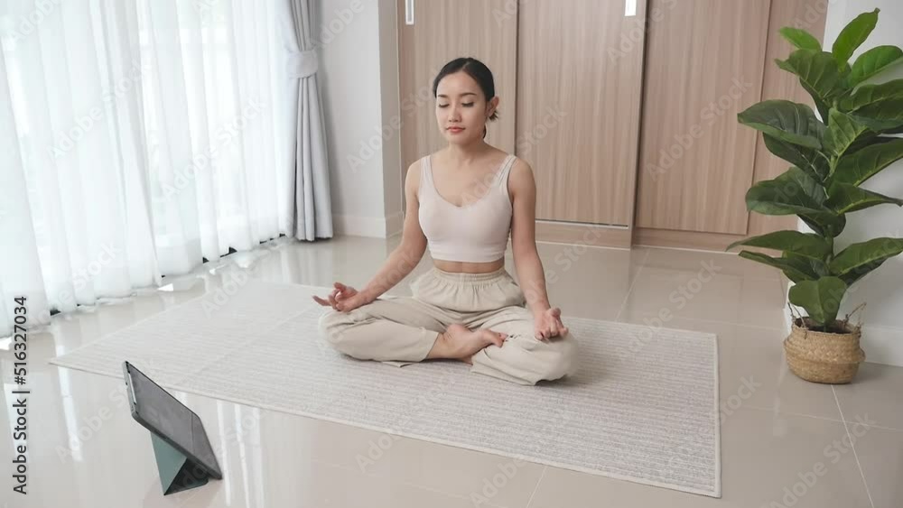 Woman studying online meditation on the floor in the living room to improve cons Woman studying online meditation on the floor in the living room to improve cons