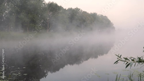 fog over the river at sunset a fisherman in a boat on the water 2022