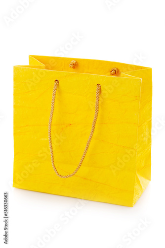 Blank yellow gift bag made of corrugated paper. Isolated on a white background.