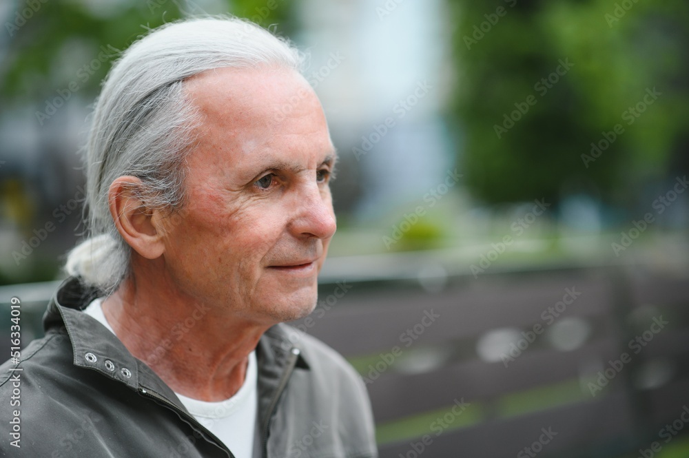 Old gray-haired man rest on the bench in summer park Old gray-haired man rest on the bench in summer park