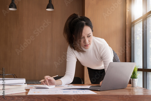 accountant, Auditor, Self-Employed, Finance and Investment, tax calculation and budget, Portrait of Asian female entrepreneur using a calculator to calculate. Company business results document