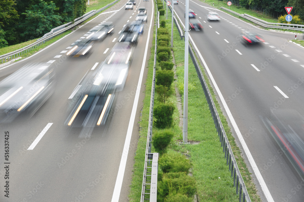 Blurred traffic on highway in sunset. Fast blurred motion drive on the highway. Transportation and travel concept Blurred traffic on highway in sunset. Fast blurred motion drive on the highway. Transportation and travel concept