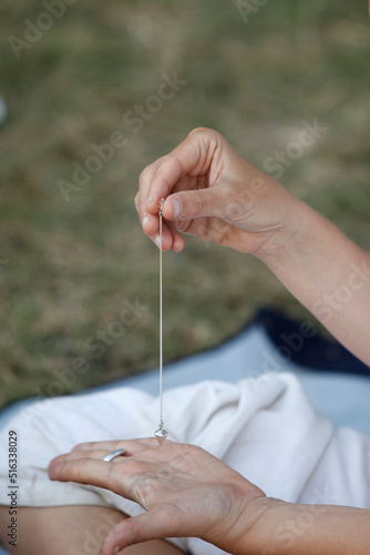Woman using a pendulum at a Kundalini Yoga festival