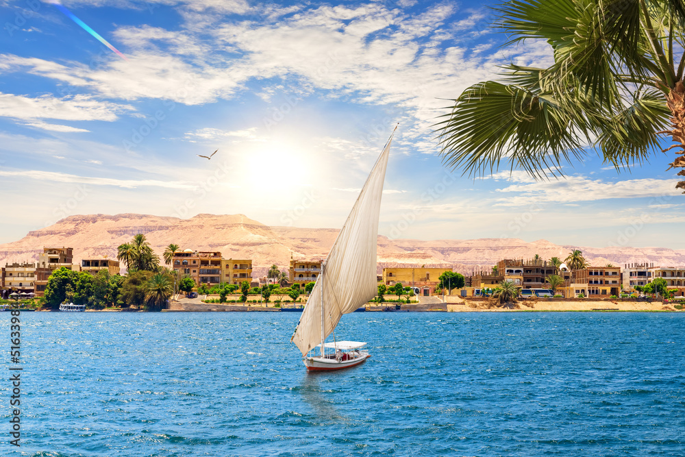 View of the Nile and a sailboat by the Valley of Kings in Luxor, Egypt