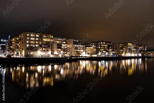 Photography Beautiful shot of buildings reflected on a lake at night in Henriksdalshamnen di