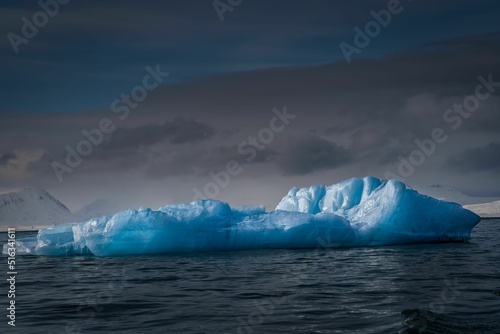 Fototapeta A LARGE PIECE OF BLUE TINTED SEA ICE FLOATING IN THE ARCTIC OCEAN NEAR SVALBARD