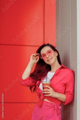 Young beautiful woman with pink hair on a bright background with lemonade