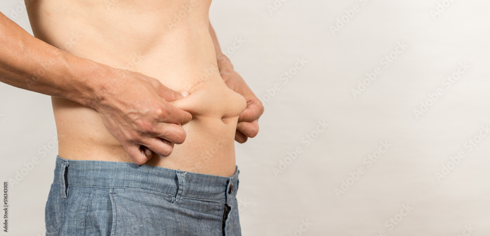 Obraz premium お腹の脂肪に気になるダイエットする男性の姿